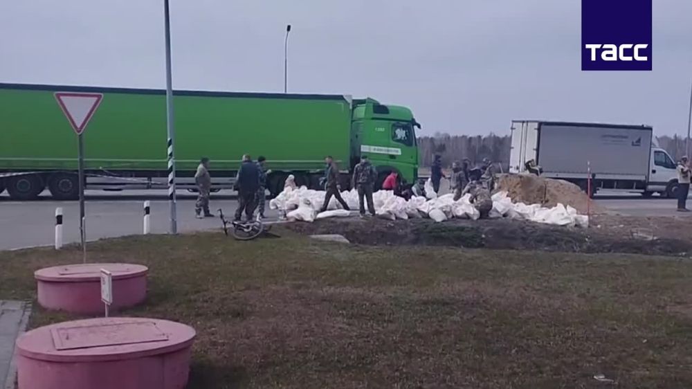 Десятки волонтеров строят дамбу для защиты от паводка участка трассы на Тюмень под Курганом, сообщает корреспондент ТАСС